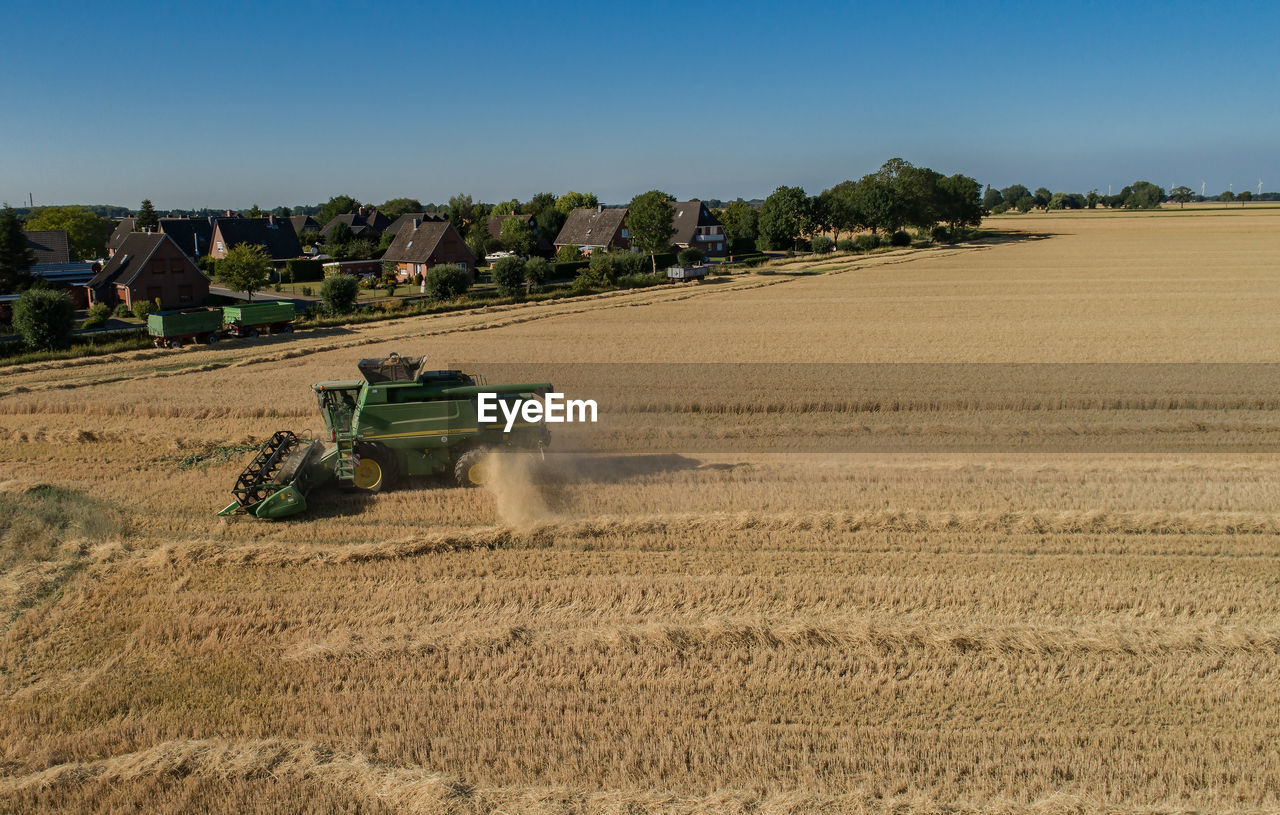 High angle view of tractor on agricultural field against clear sky during sunny day