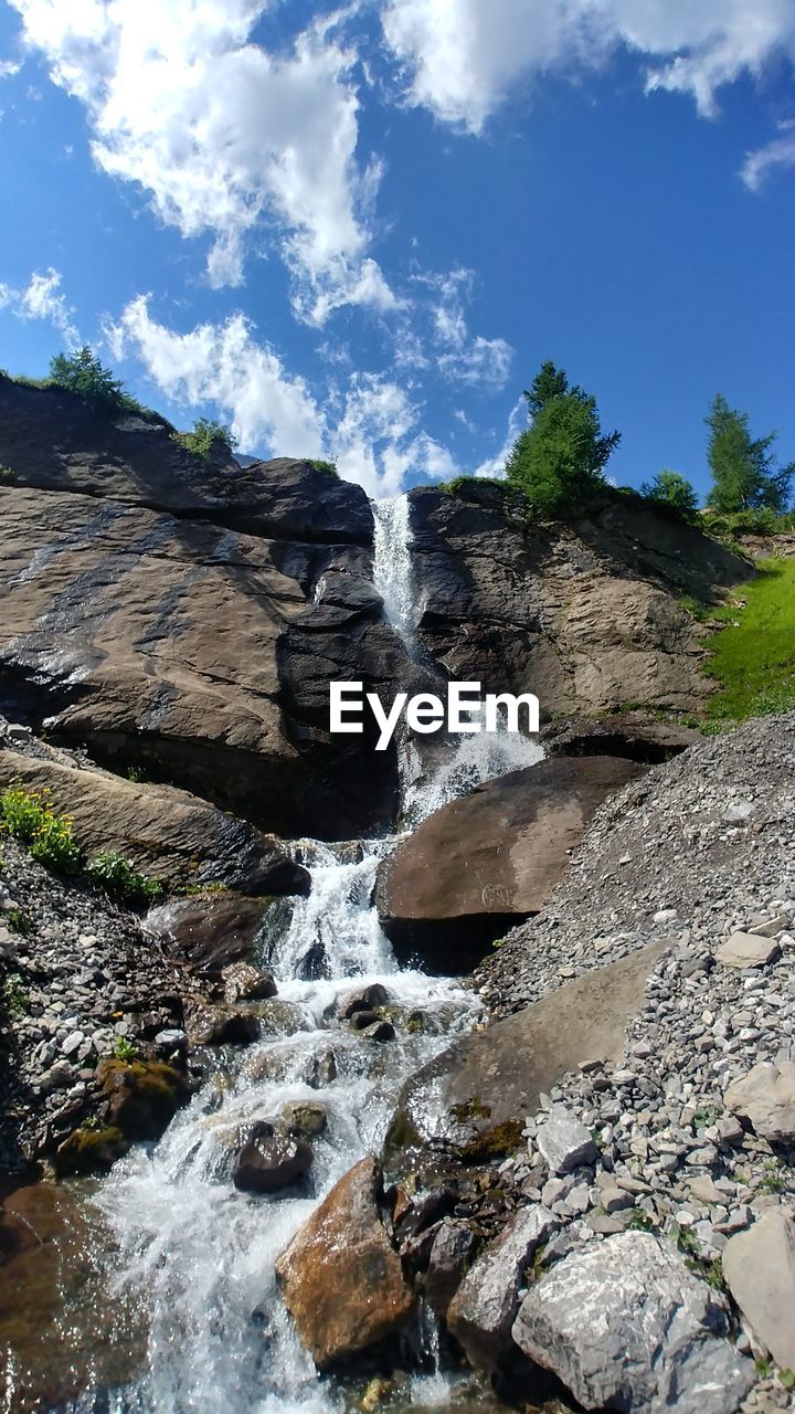 Scenic view of waterfall in forest against sky