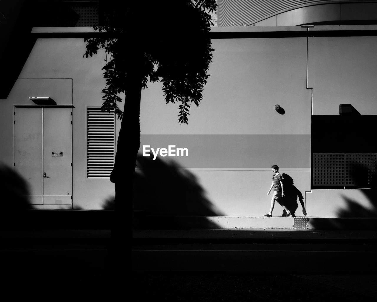 SIDE VIEW OF SILHOUETTE MAN AGAINST BUILDING