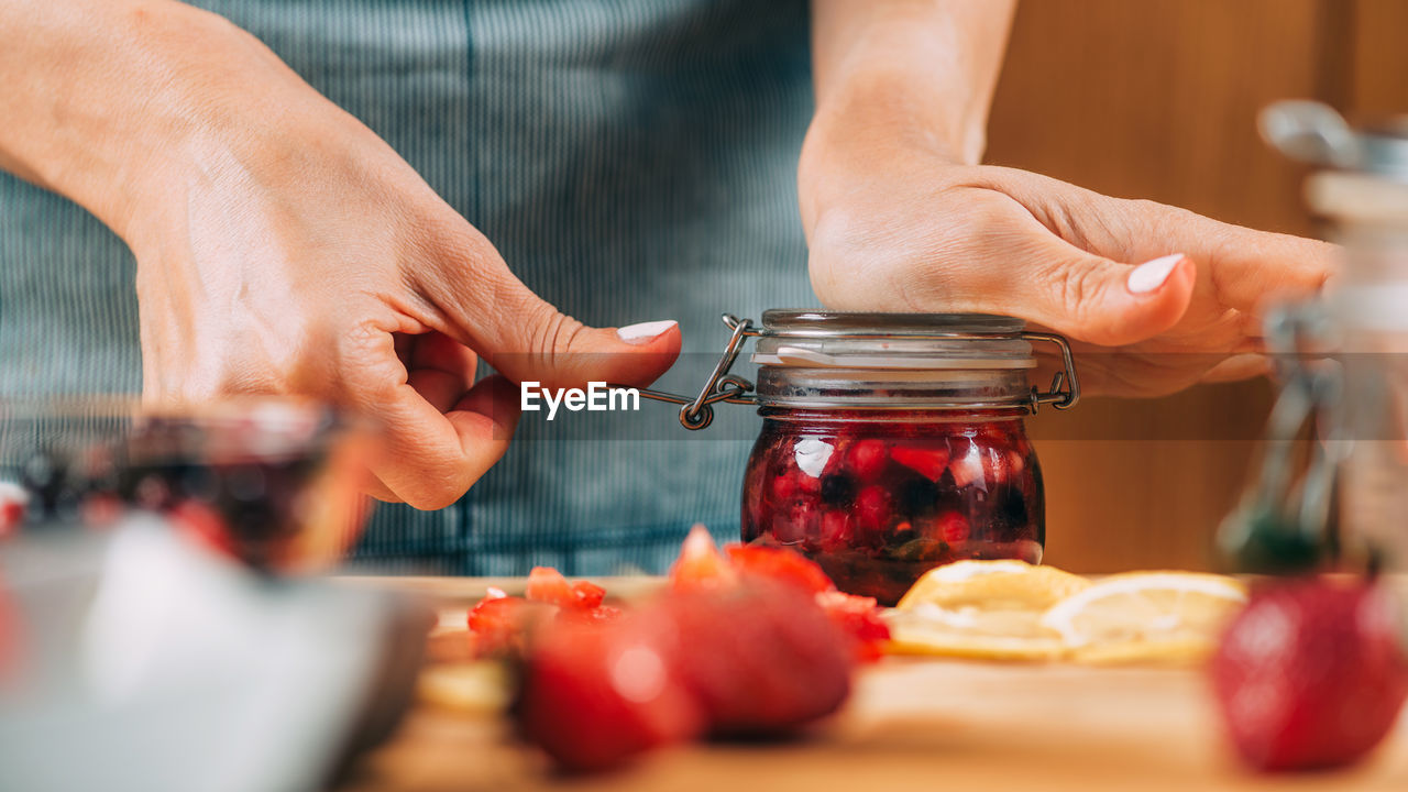 Fruit fermentation. woman holding jar with fermented fruit.