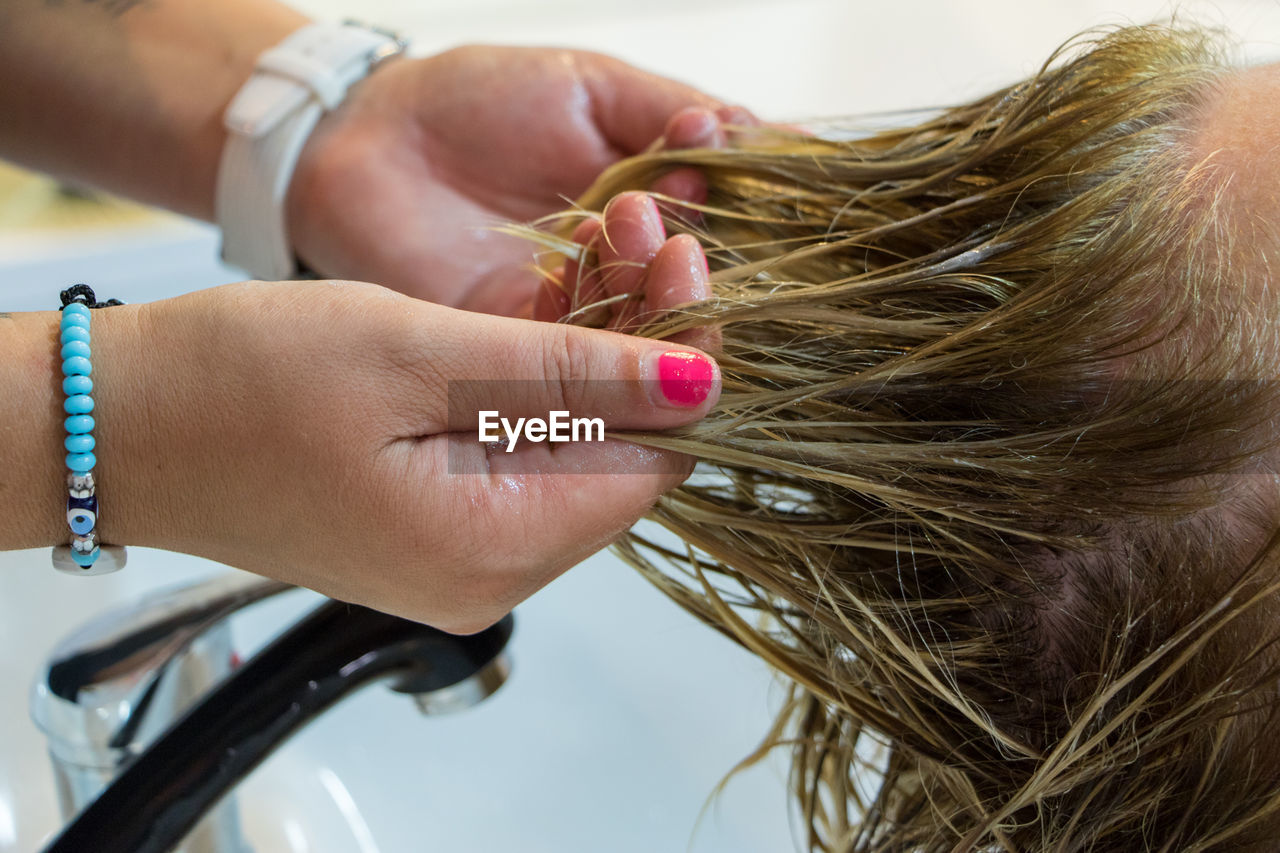 Cropped hands hair styling customer