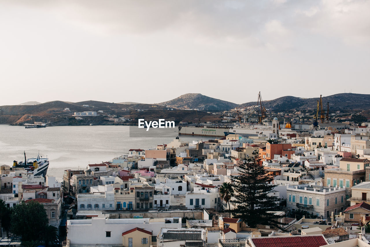 High angle view of townscape by sea against sky