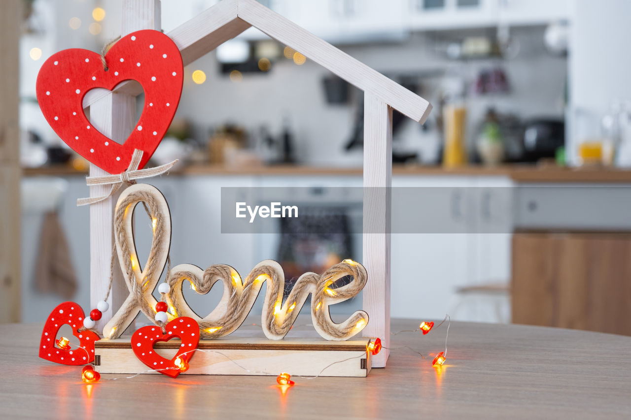 heart shape, indoors, love, no people, positive emotion, domestic room, emotion, red, home interior, decoration, celebration, home, table, focus on foreground, domestic life, candle, kitchen, food and drink, domestic kitchen, wood, lifestyles, still life