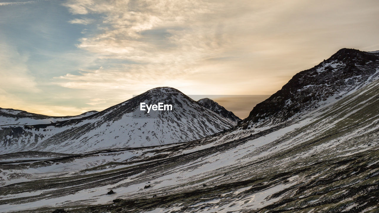 Scenic view of snowcapped mountains against sky during sunset