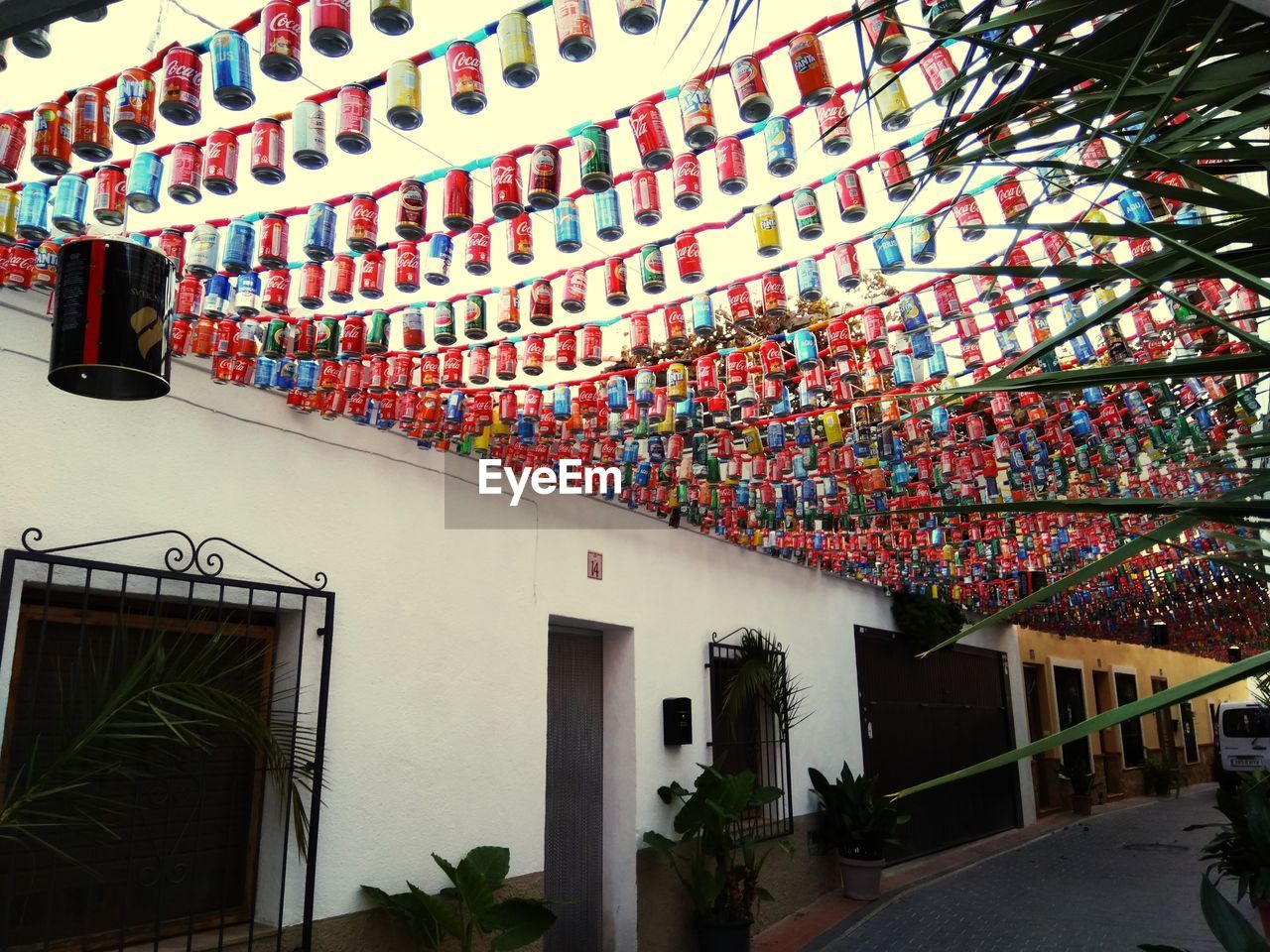 LOW ANGLE VIEW OF MULTI COLORED HOUSES HANGING BY BUILDING