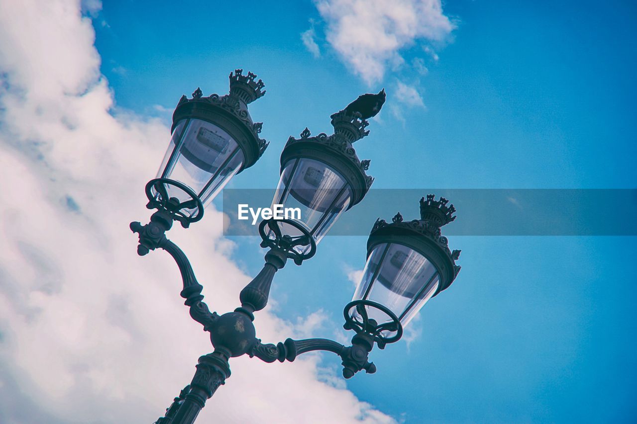 Low angle view of street light against cloudy sky