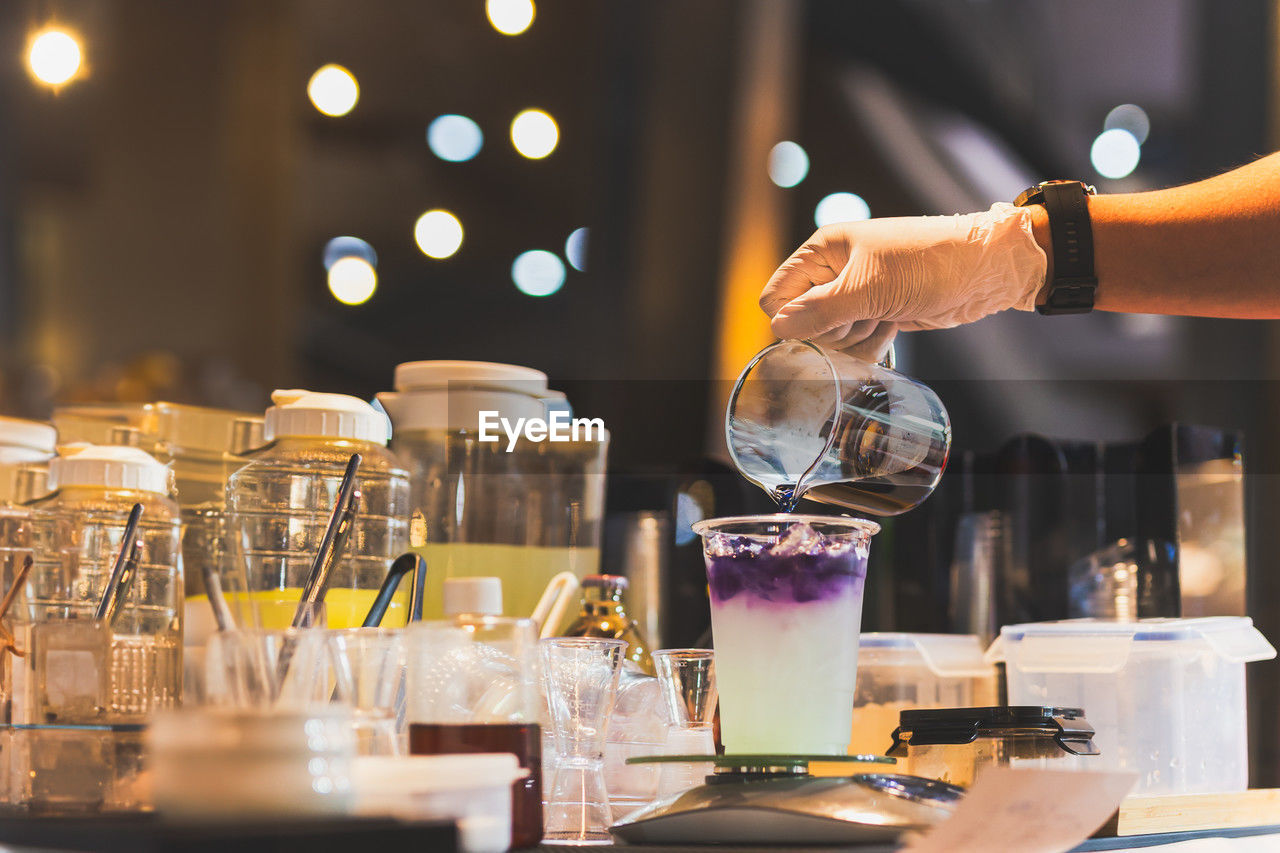 Man making butterfly tea with yuzu juice in a tak away glasses.