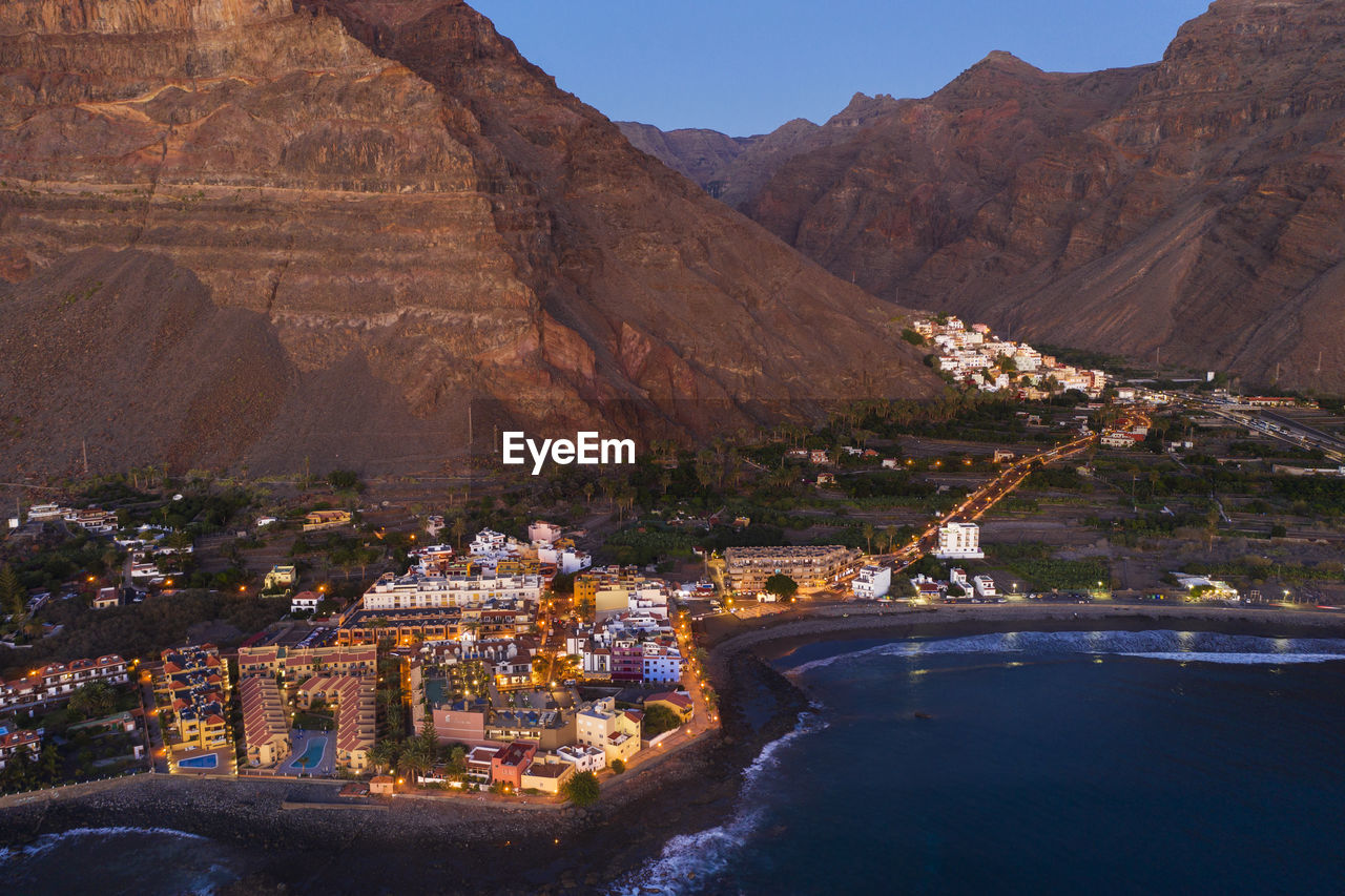 Spain, valle gran rey, drone view of town at edge of la gomera island at dusk