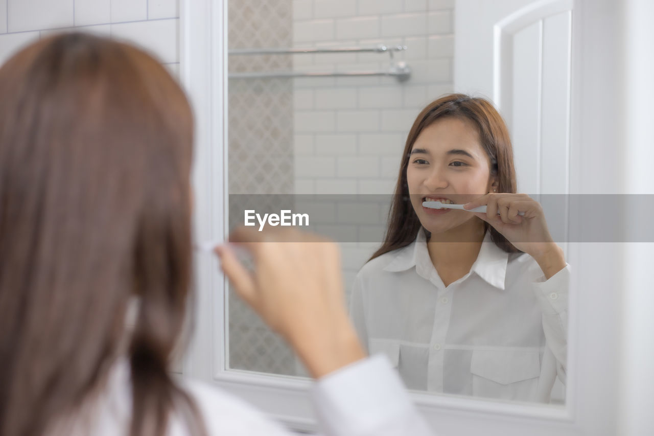 PORTRAIT OF A BEAUTIFUL YOUNG WOMAN IN A BATHROOM