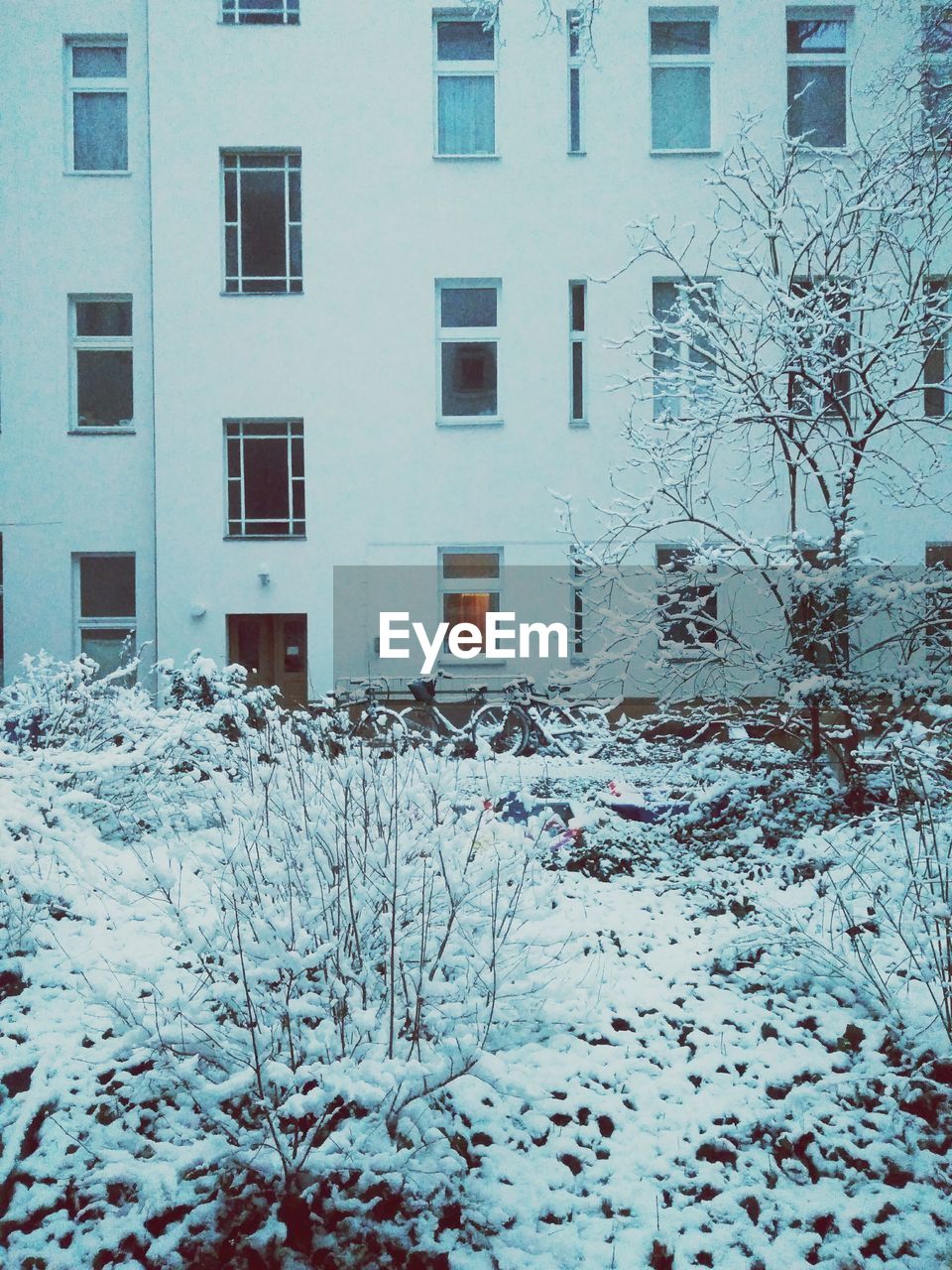 Snow covered field against building