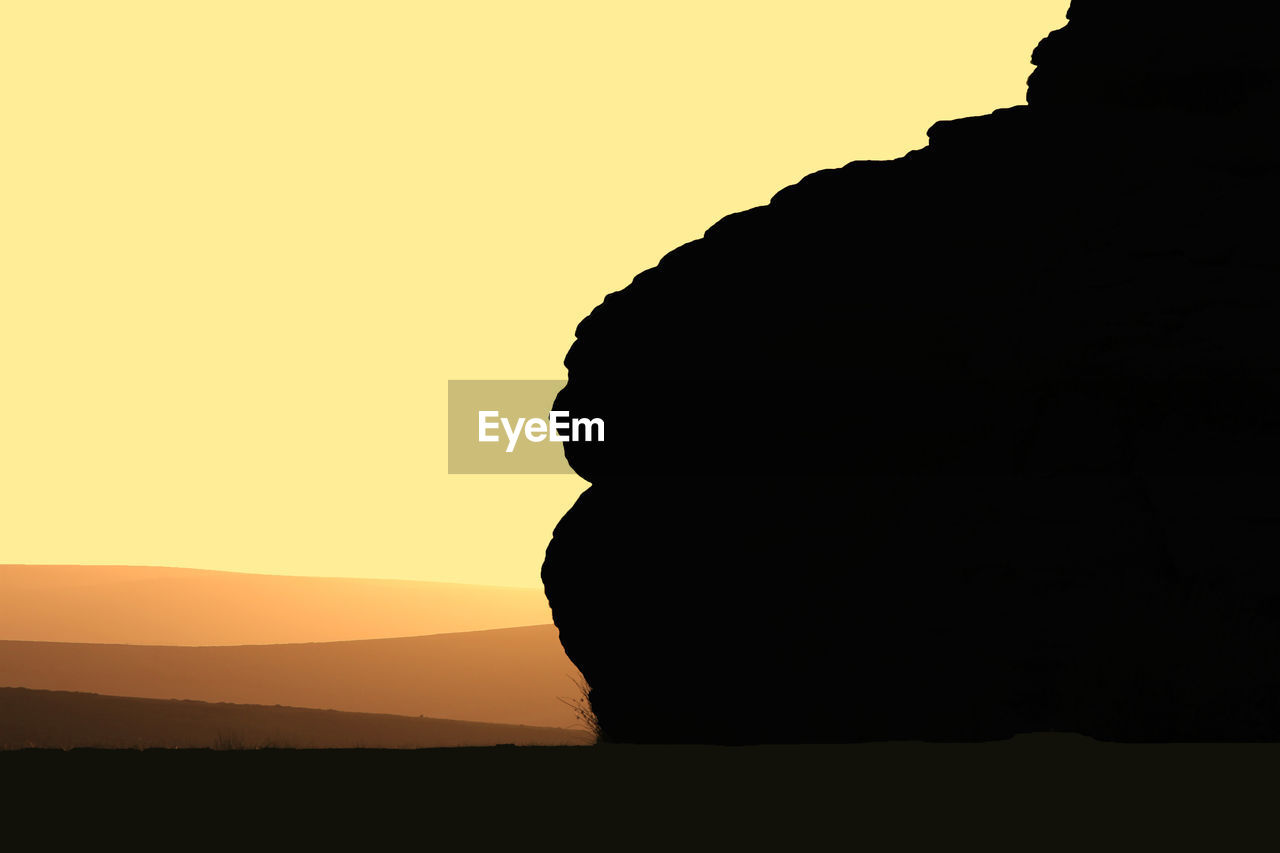 Silhouette of rock against clear sky