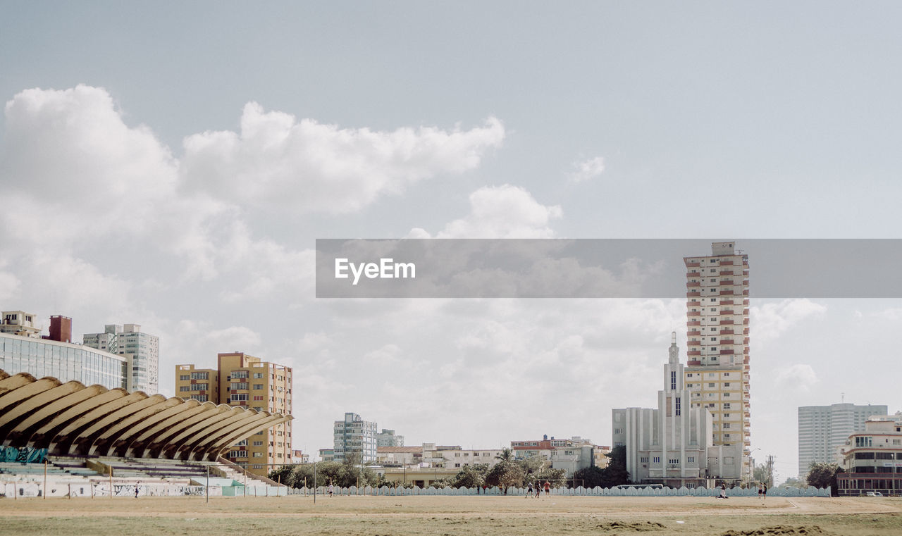 Soccer field against sky in city