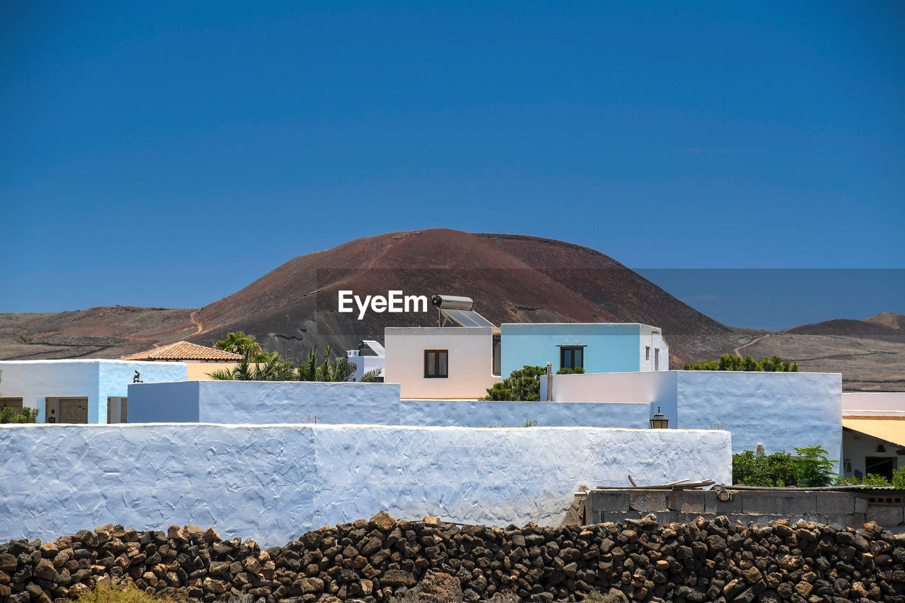 View of houses against mountain and sky