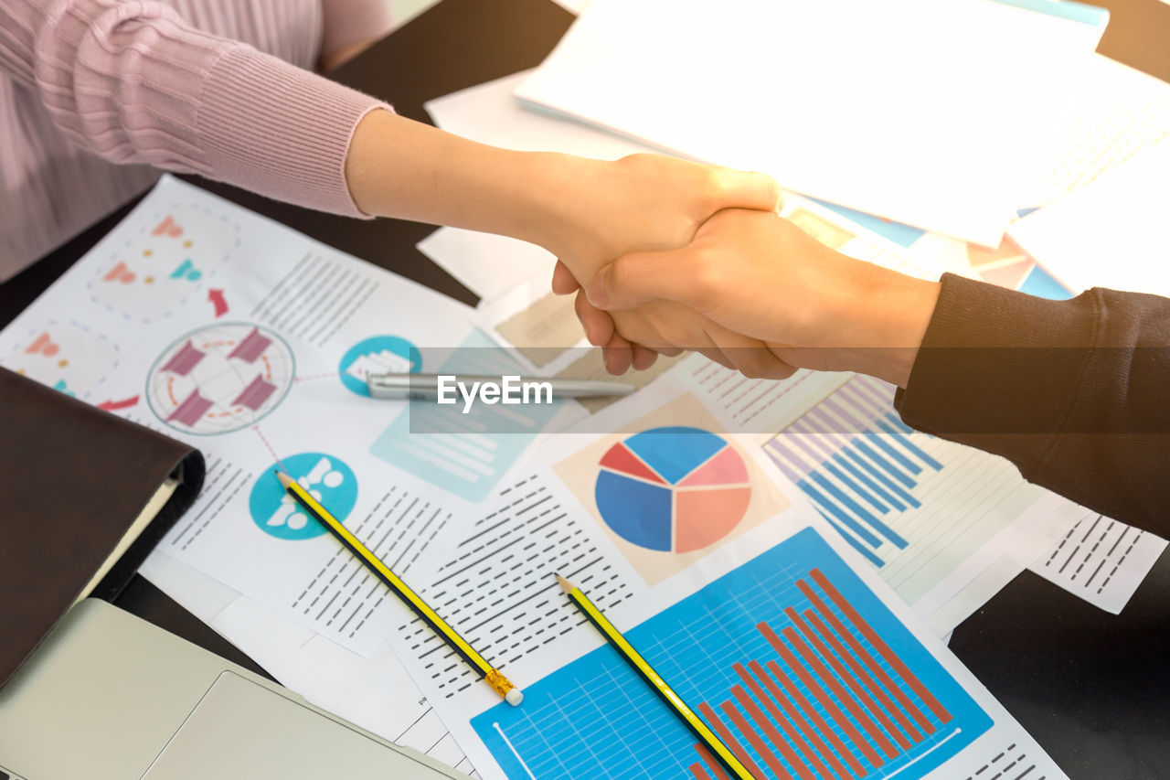 High angle view of business people shaking hands in office