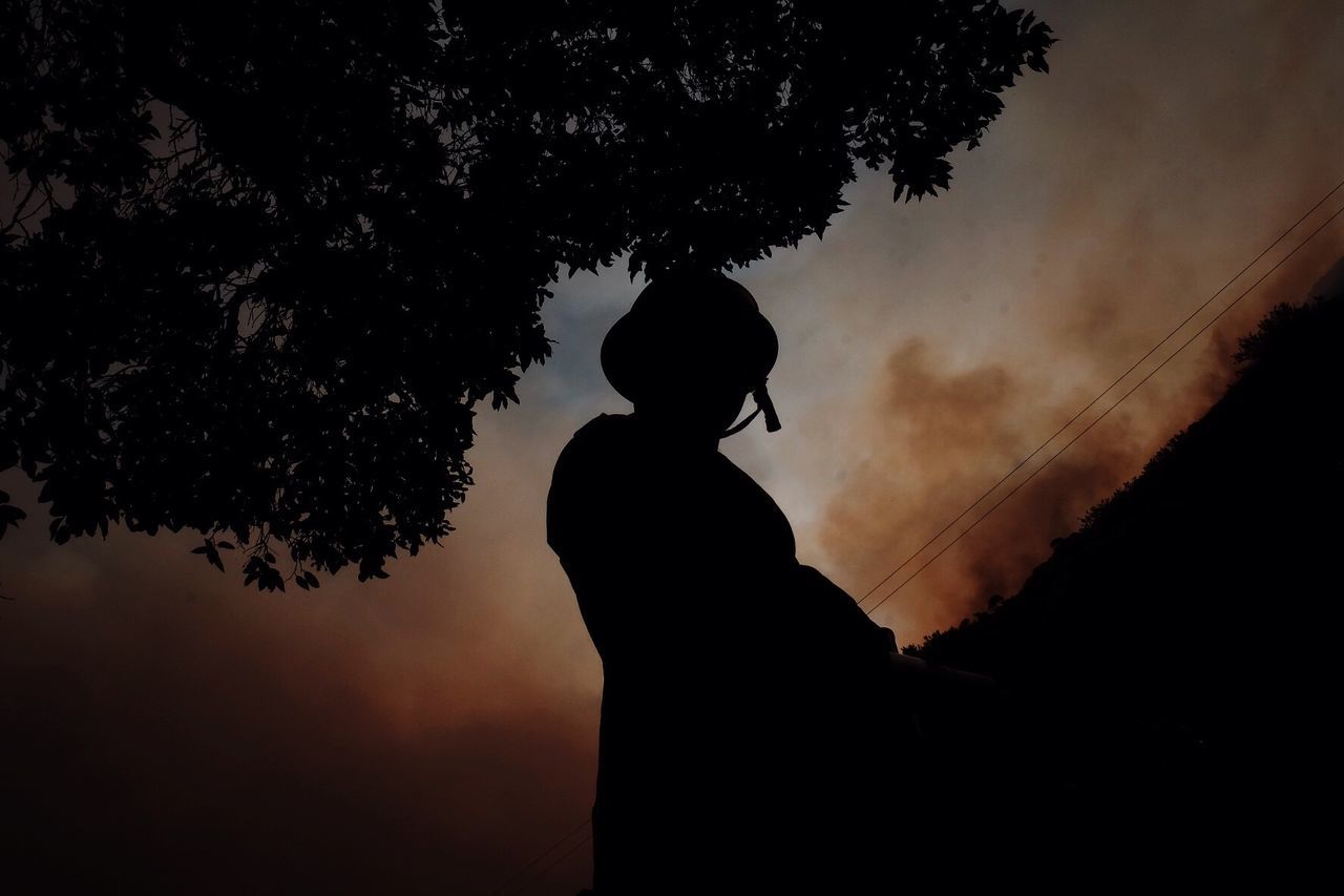 Low angle view of silhouette woman against the sky