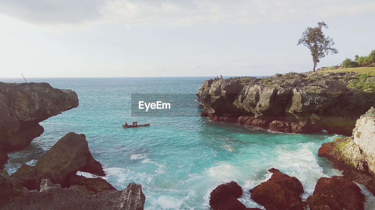 Scenic view of sea and mountain against sky