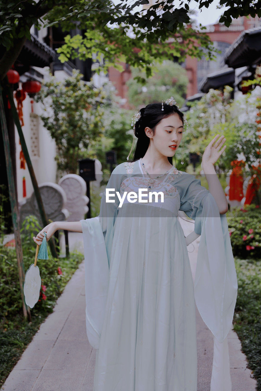 portrait of young woman standing in traditional clothing