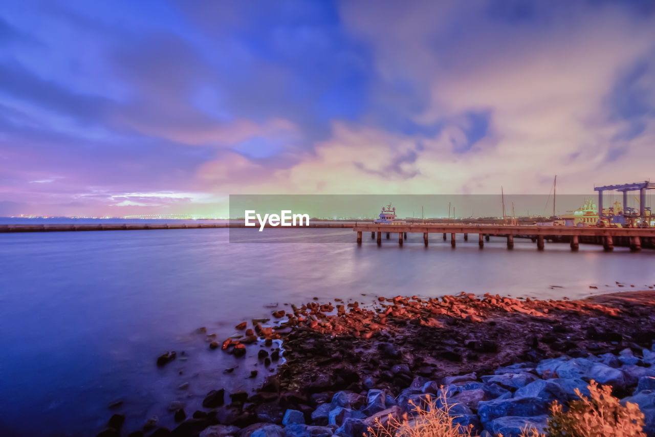 PIER OVER SEA AGAINST SKY DURING SUNSET