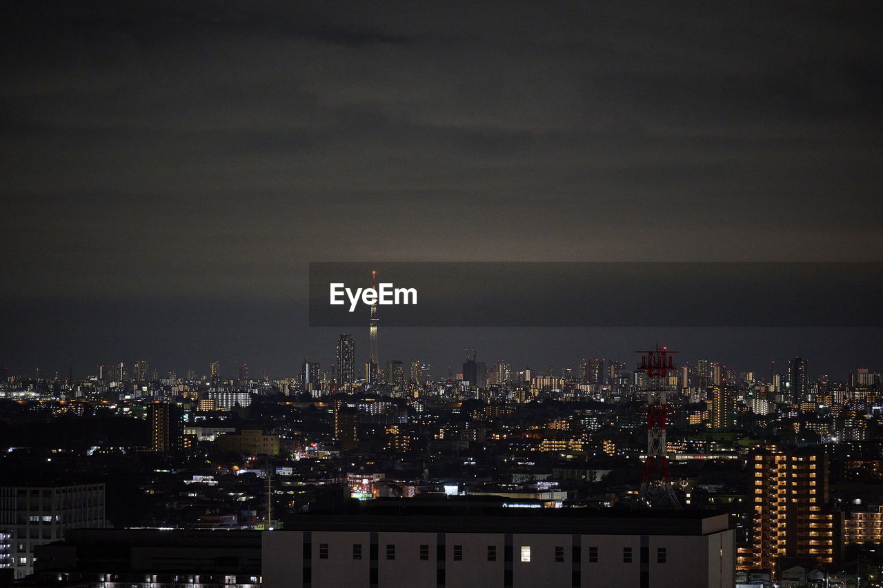 Illuminated cityscape against sky at night