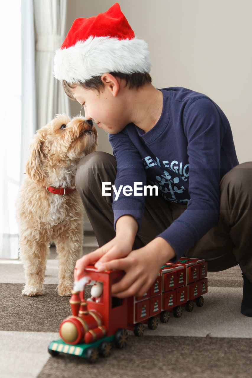 MIDSECTION OF MAN WITH DOG AT HOME