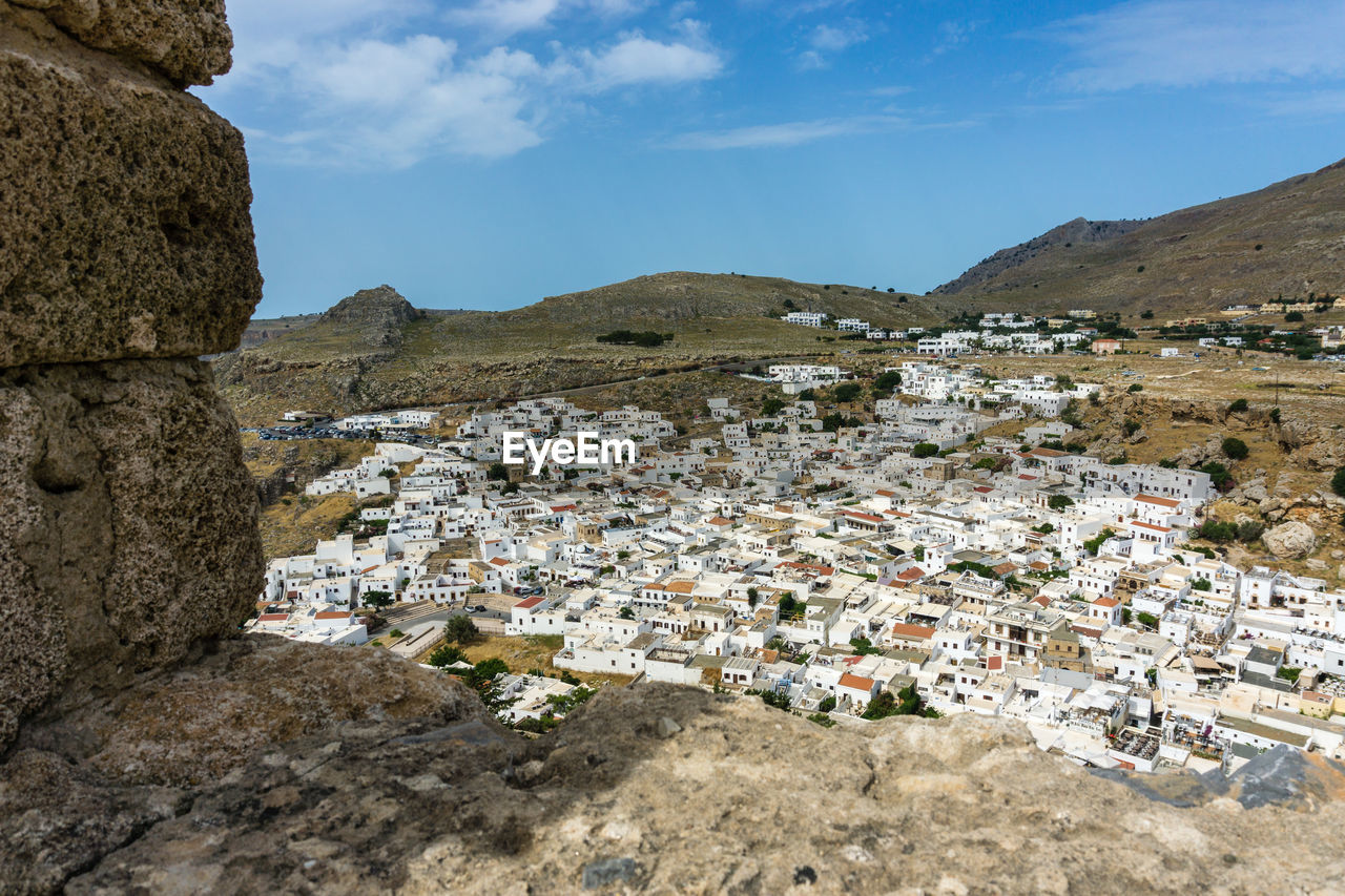 Aerial view of town by buildings against sky