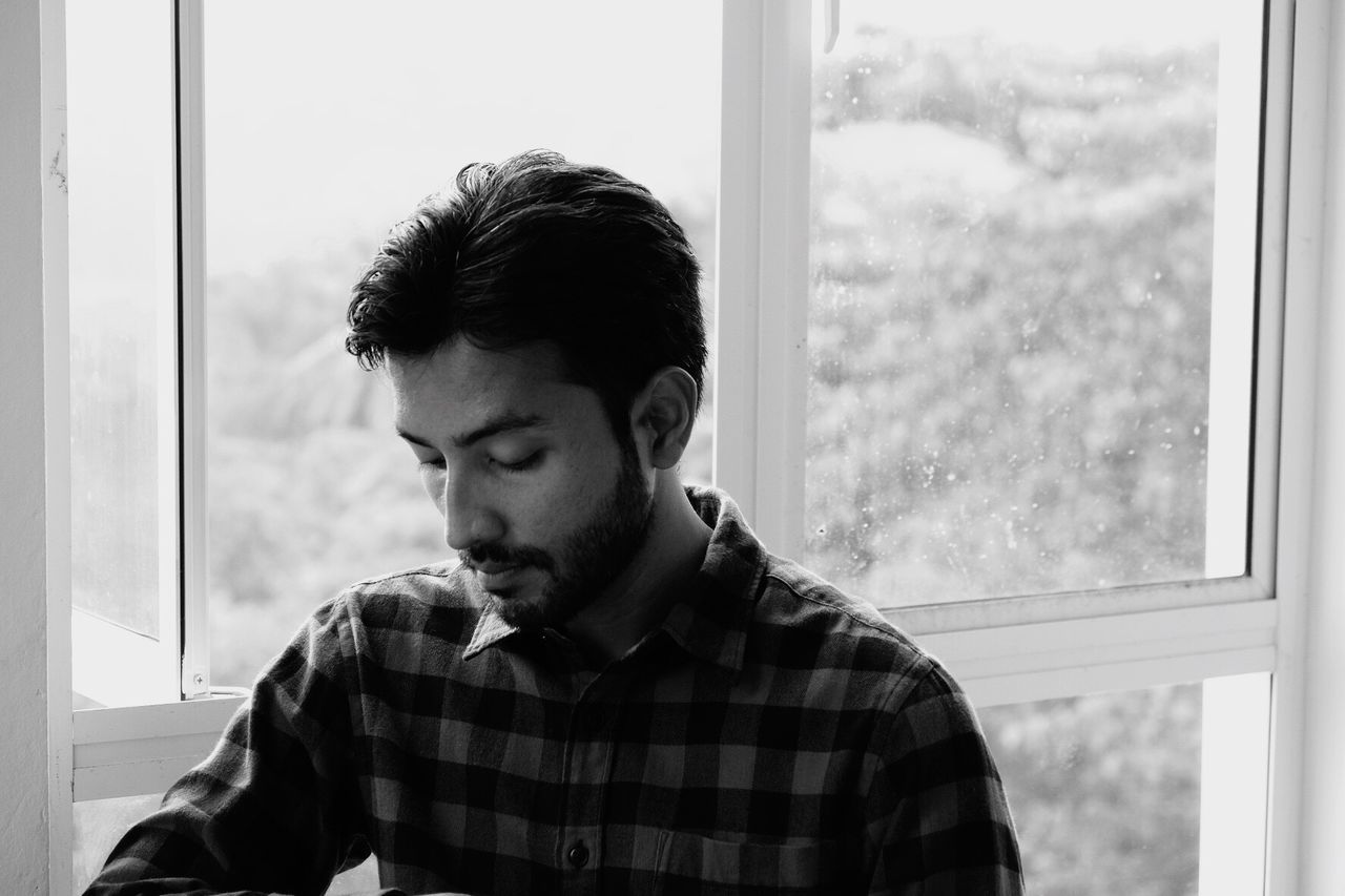 Close-up of man against window