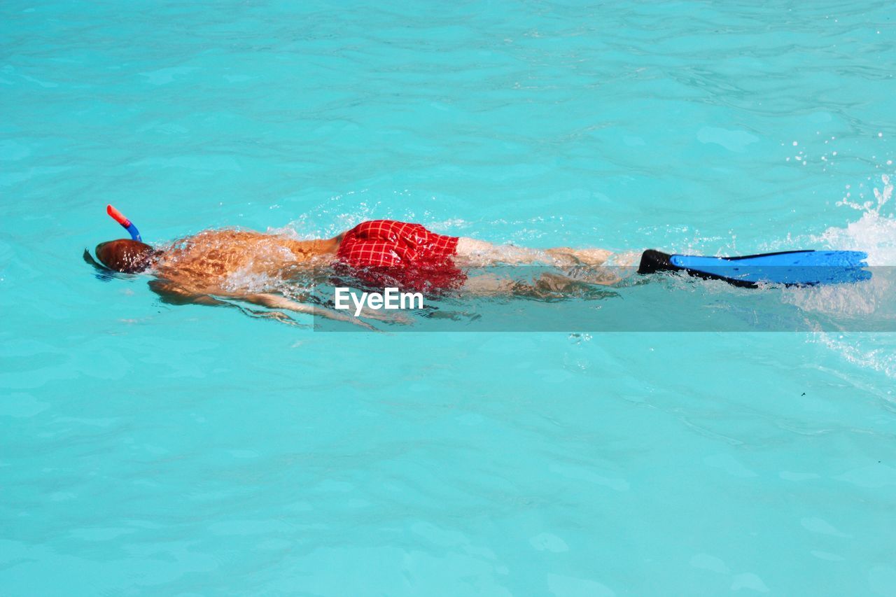 High angle view of man snorkelling in turquoise water