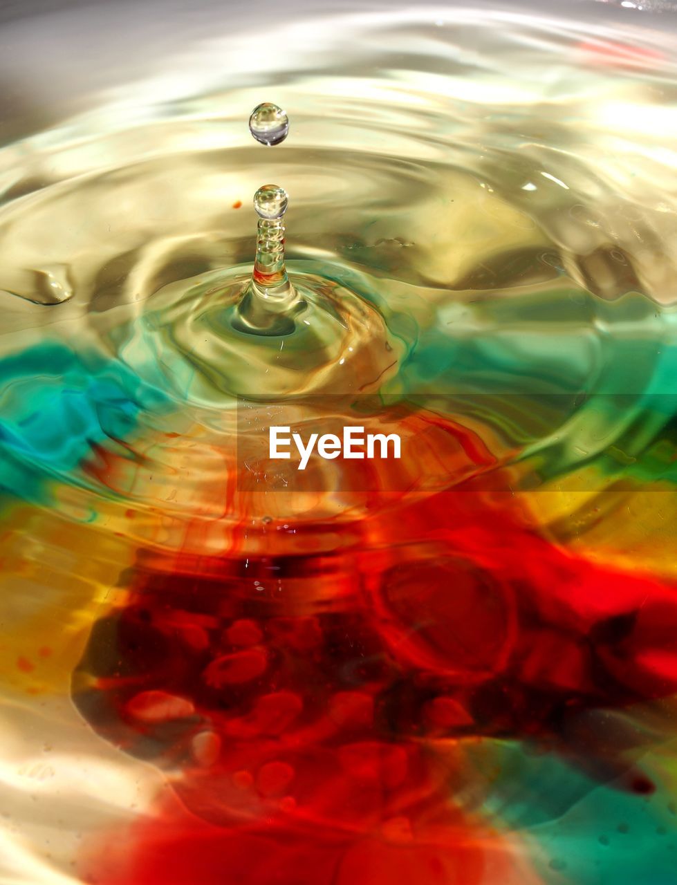 Detail of drop splashing in colorful water