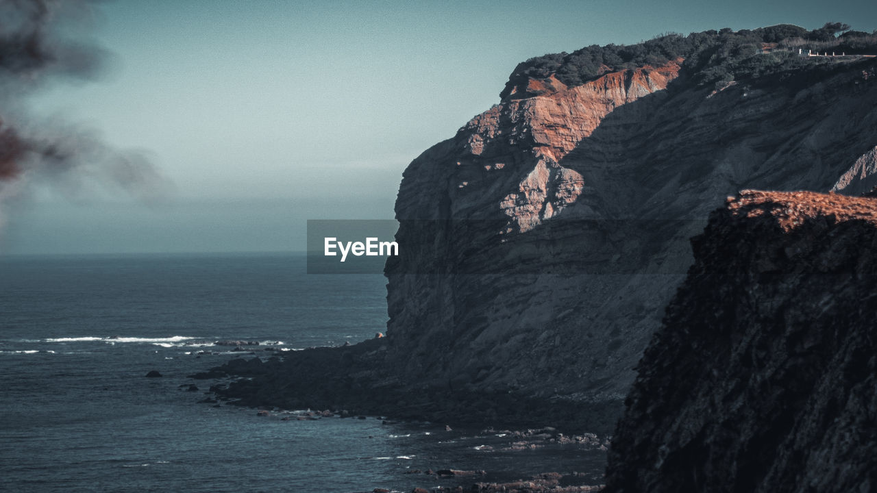 Rock formations by sea against sky
