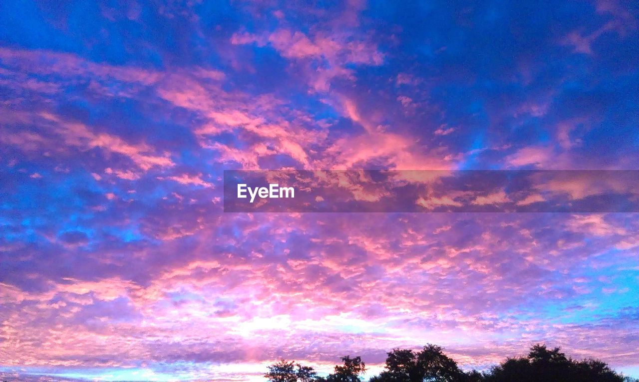 Low angle view of cloudy sky during sunrise