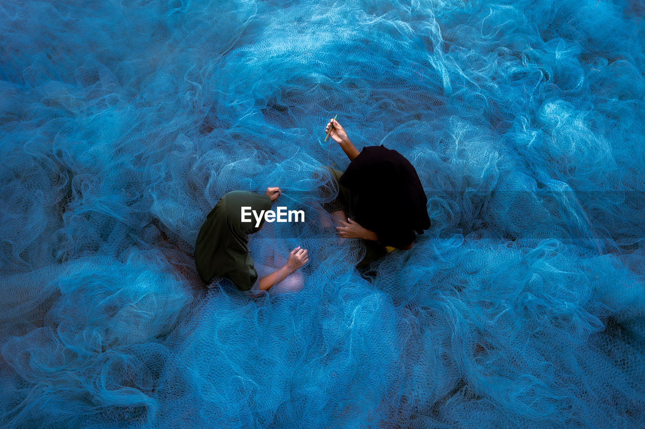 High angle view of two muslim making the blue trawl 