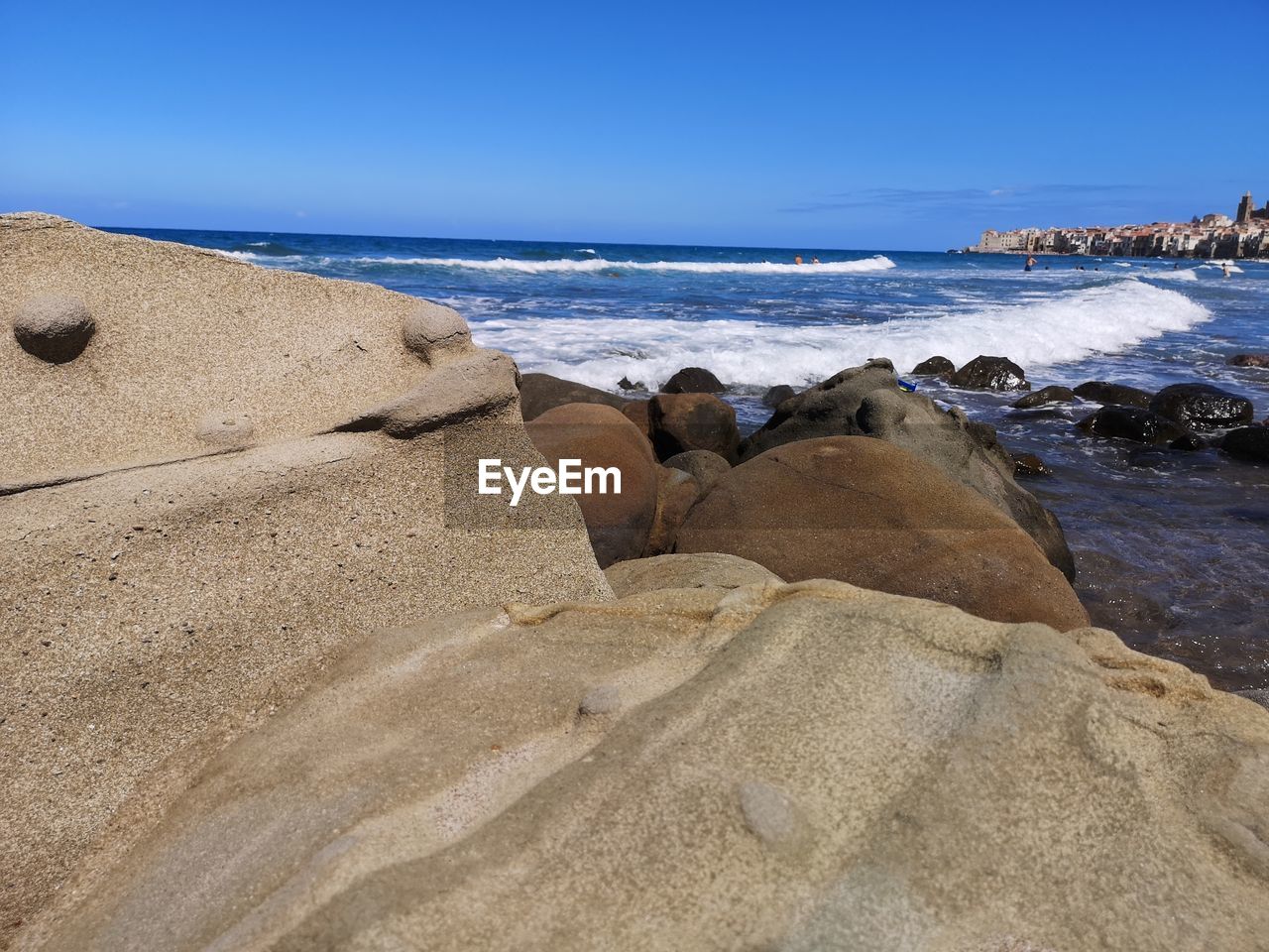 Rocks on beach against clear sky