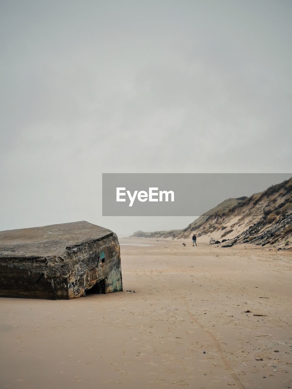 A ruin of a bunker hidden beneath the sand