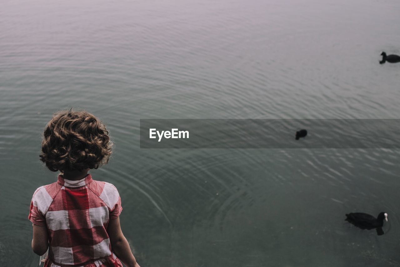 High angle view of girl standing by lake