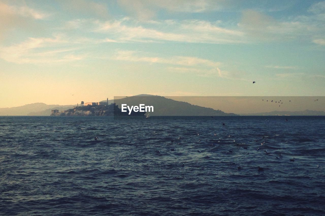 Scenic view of sea and mountains against sky