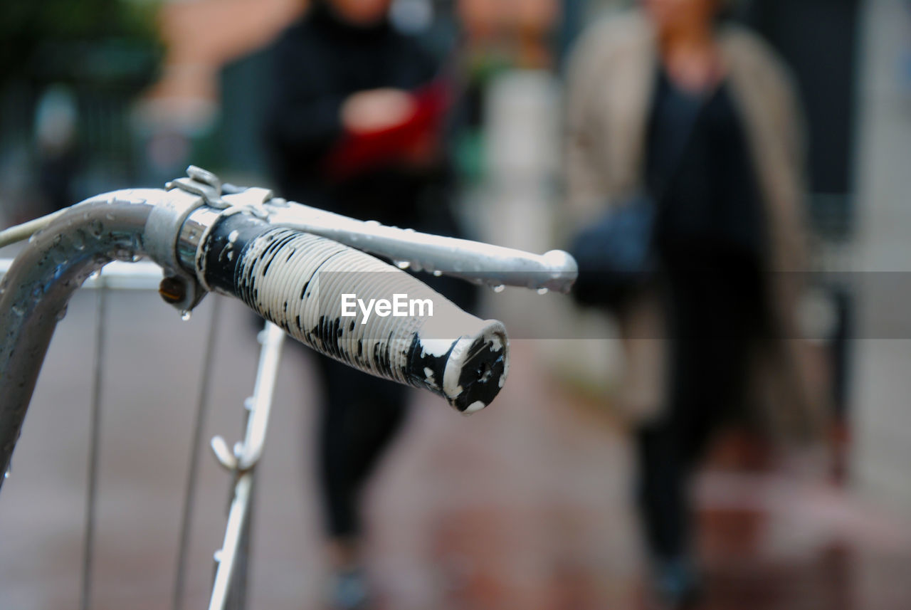Close-up of wet bicycle handle on street