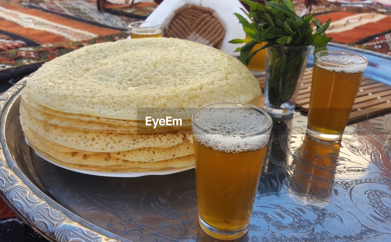 Stacked pancakes and beer on a tray