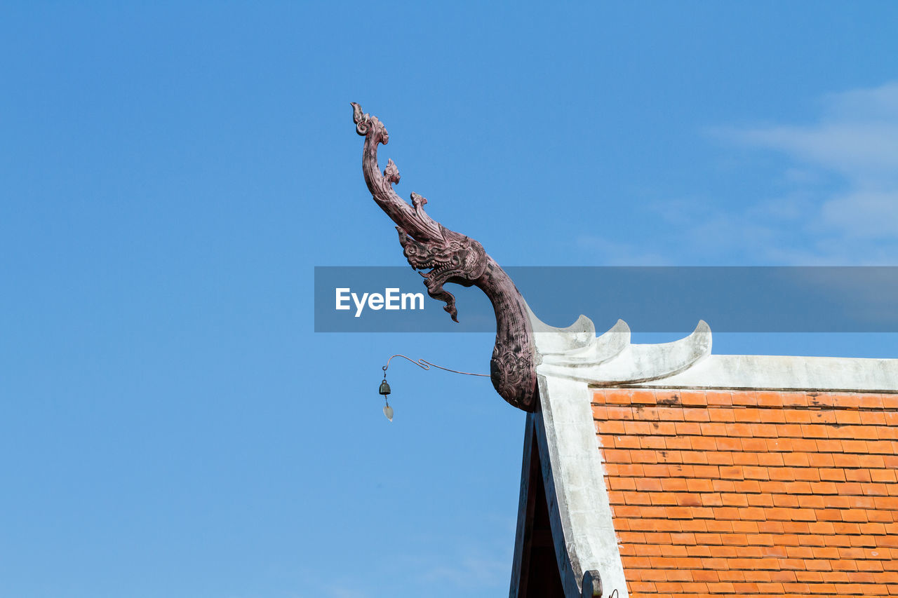 Low angle view of dragon sculpture on roof against sky at royal flora ratchaphruek