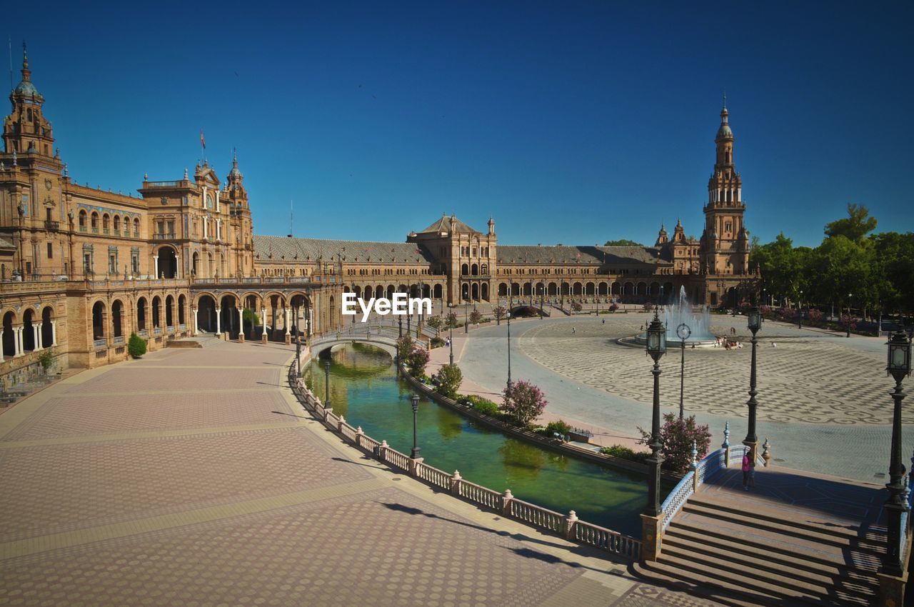 View of historic buildings in city against clear blue sky