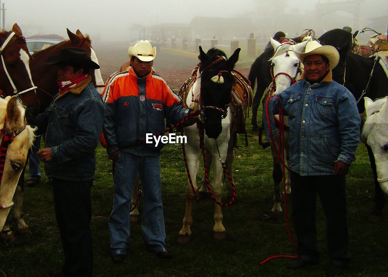 GROUP OF PEOPLE STANDING ON FIELD AT MARKET