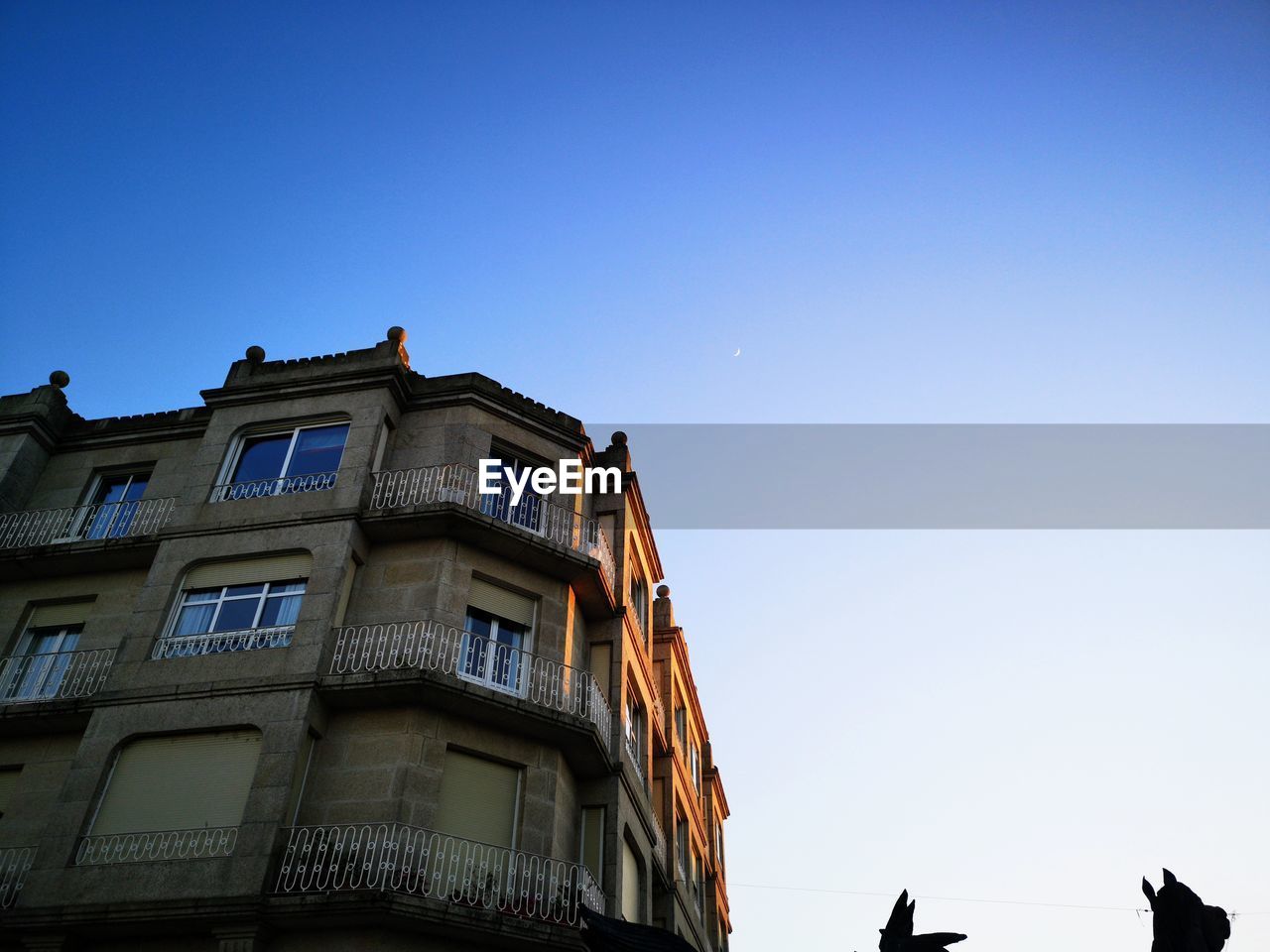 Low angle view of building against clear blue sky