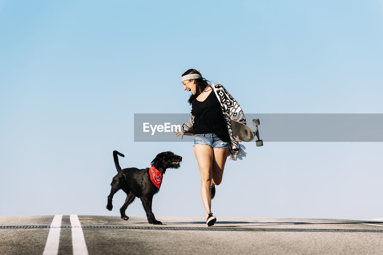 People with dog against clear sky