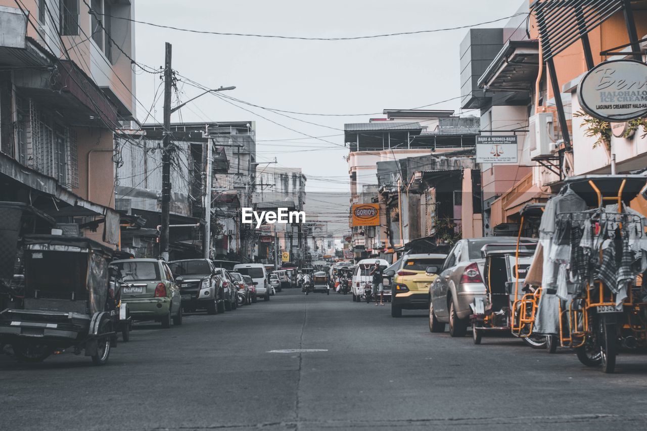 architecture, road, street, city, transportation, building exterior, built structure, mode of transportation, transport, lane, urban area, vehicle, day, sky, building, infrastructure, town, city street, residential district, land vehicle, cable, motor vehicle, car, outdoors, nature, the way forward, residential area, sign, city life, wheel
