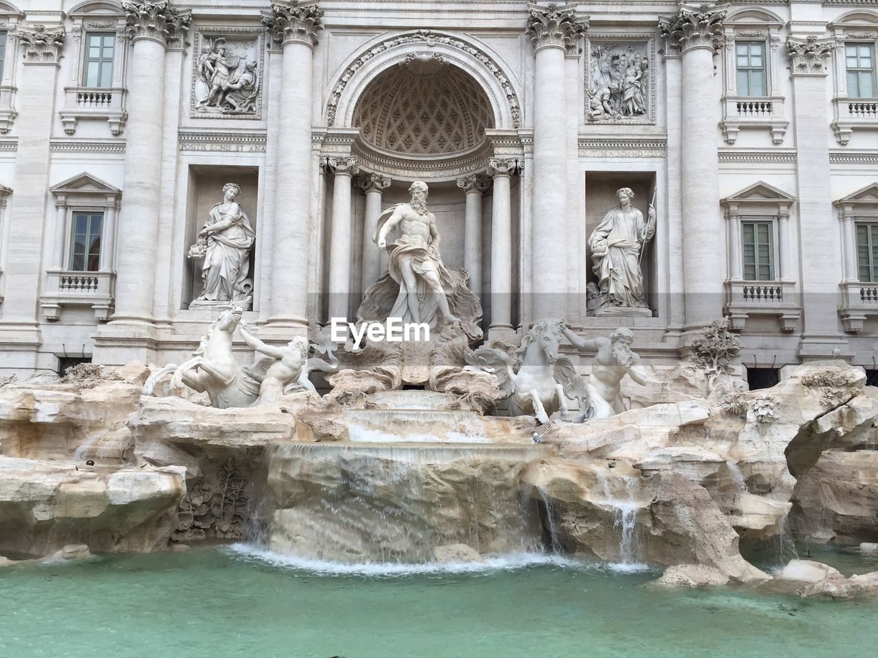 STATUE OF FOUNTAIN IN FRONT OF BUILDING