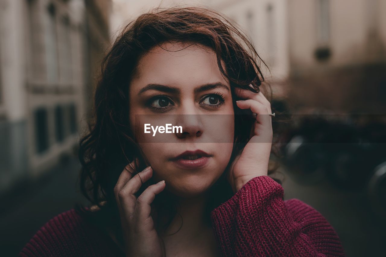 Close-up of mid adult woman looking away in city