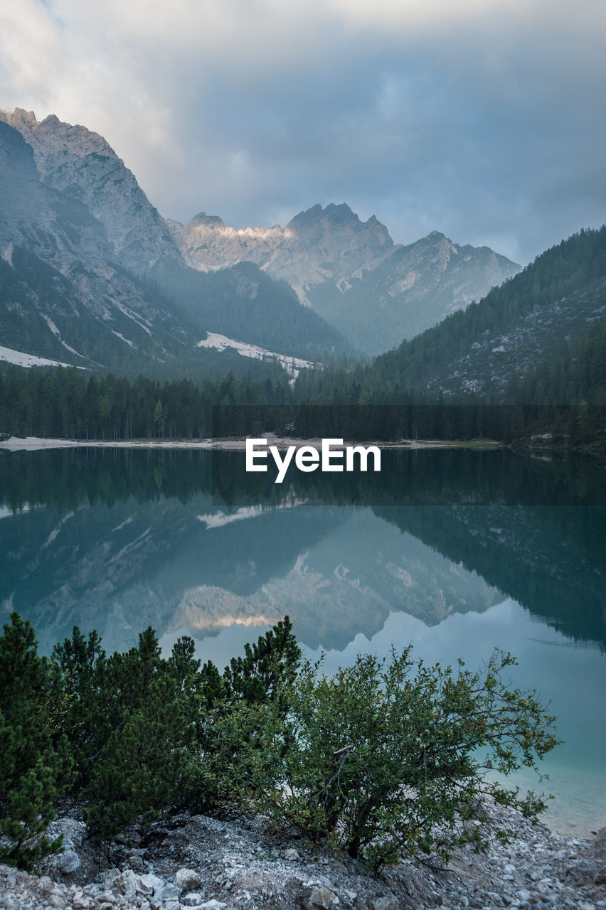 Scenic view of lake by mountains against sky