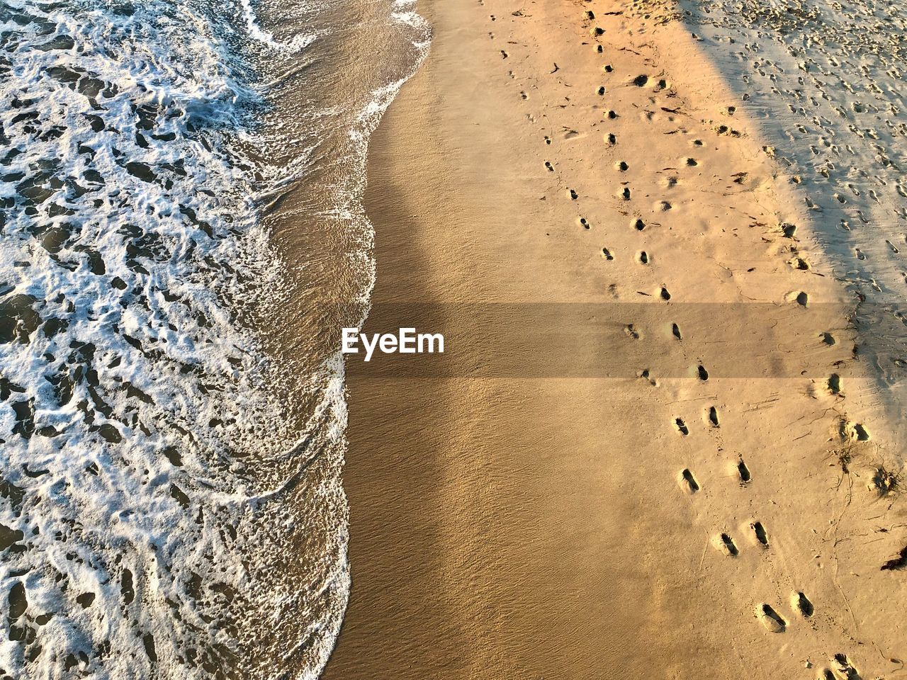 High angle view of footprints on sand at beach