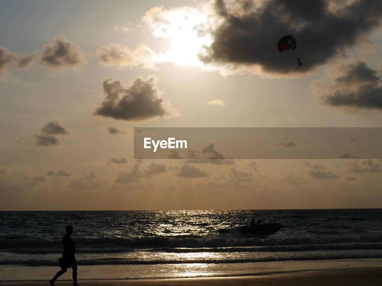 SILHOUETTE PERSON AT BEACH DURING SUNSET