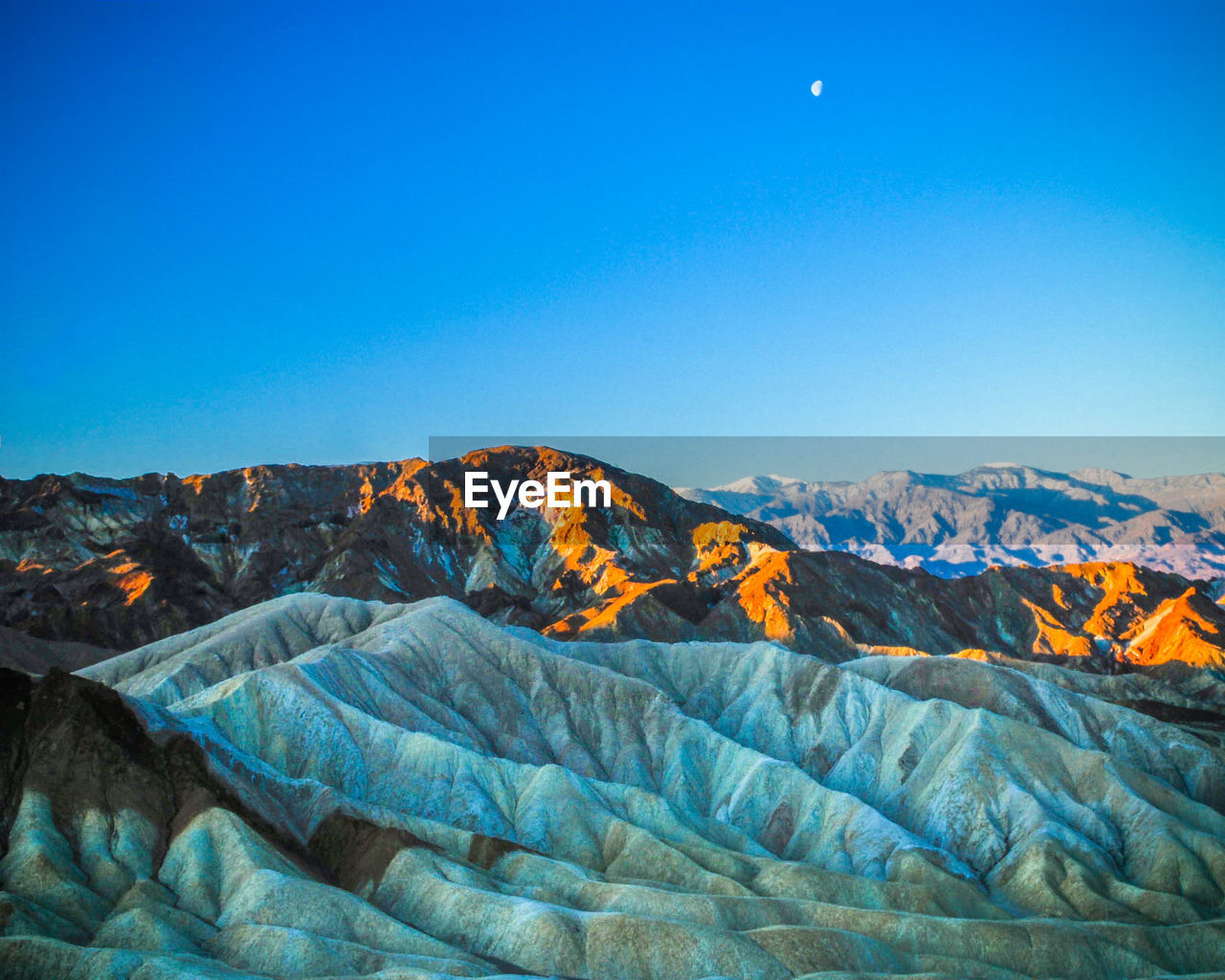 Scenic view of mountains against clear blue sky