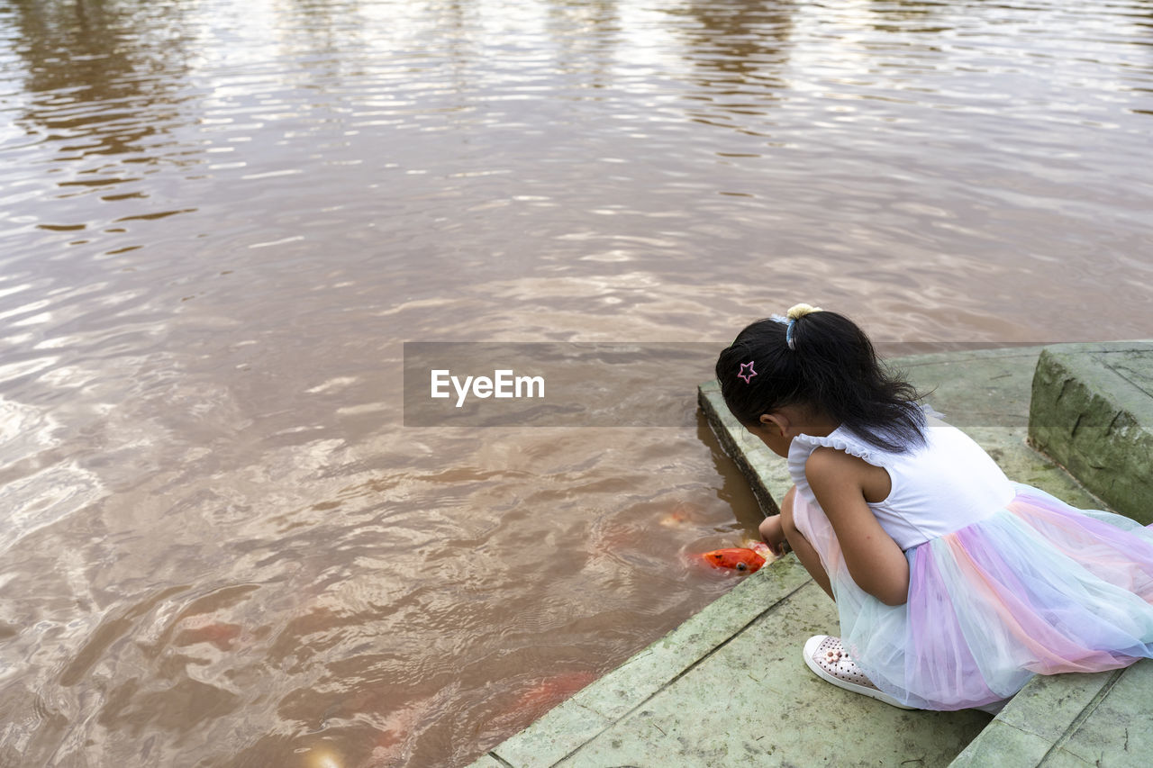 rear view of woman sitting in lake